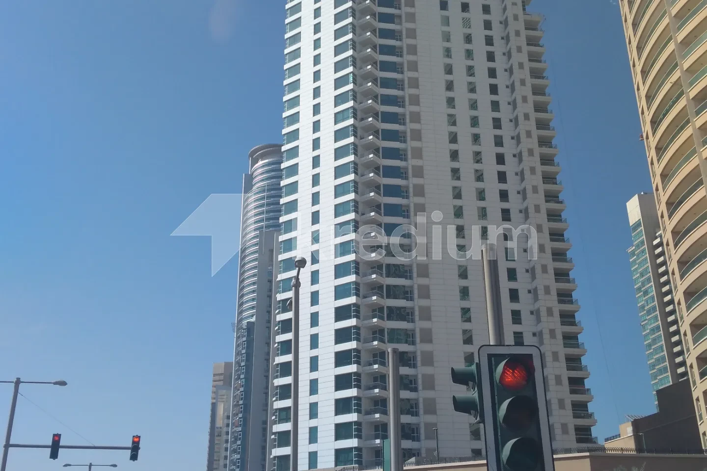 A high-rise residential tower with blue skies in the background