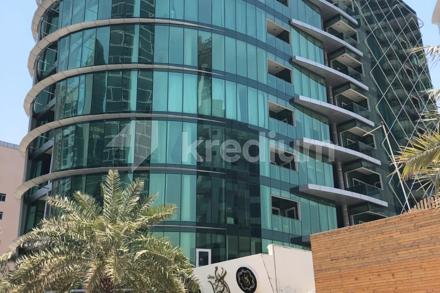 A glass round building surrounded by palm trees