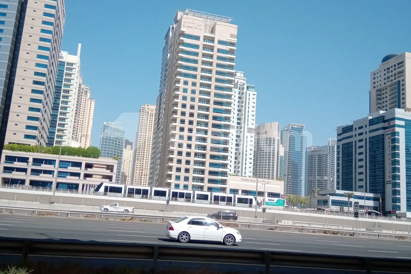 A modern high-rise building overlooking a busy road