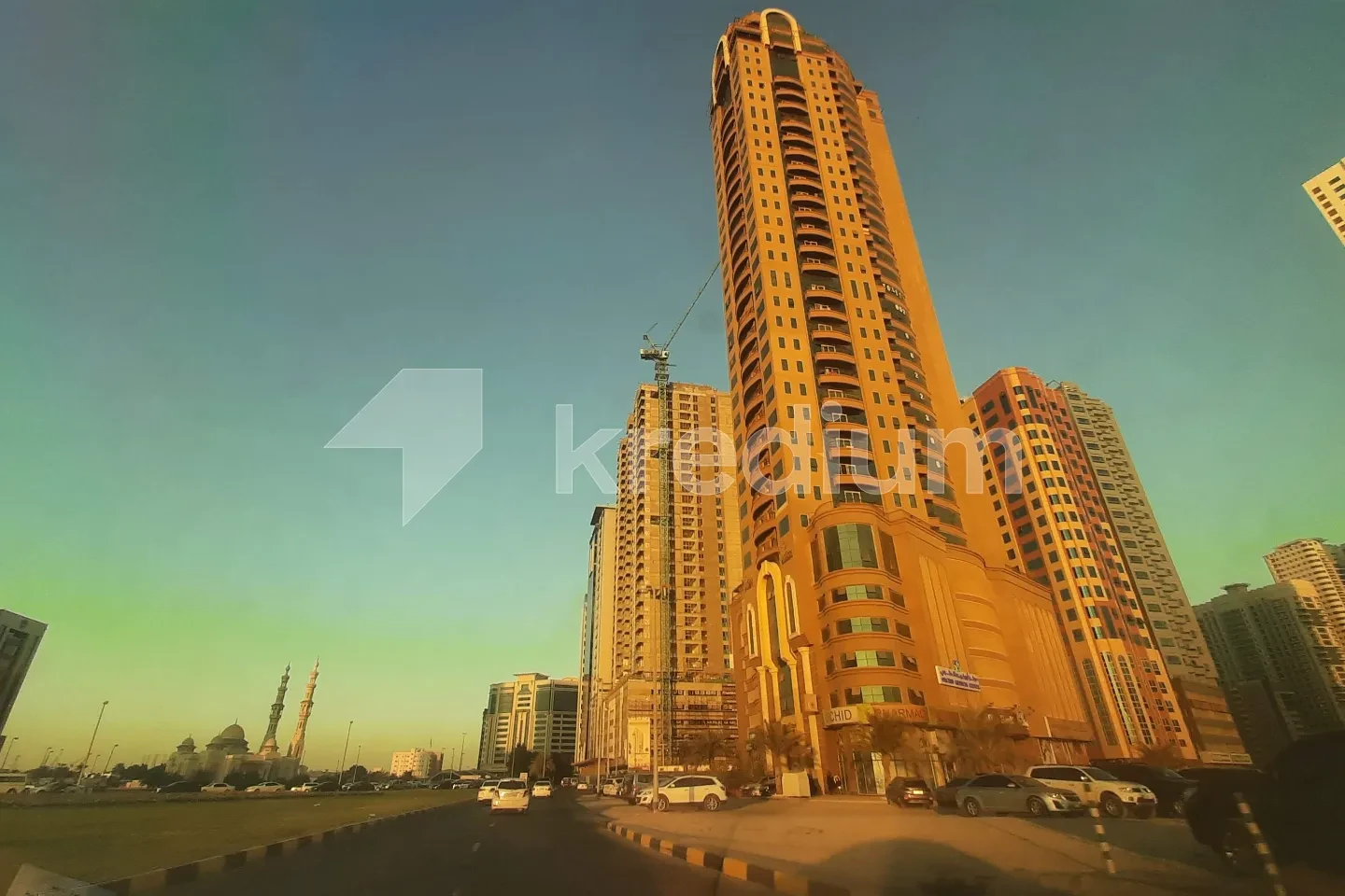 A high-rise modern building with a road running next to it