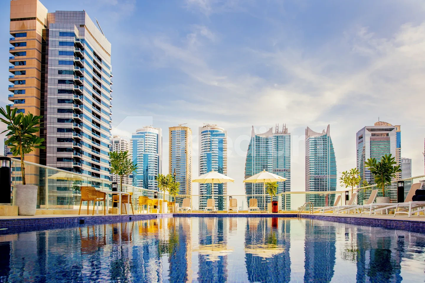 A group of elegant glass towers overlooking a large swimming pool