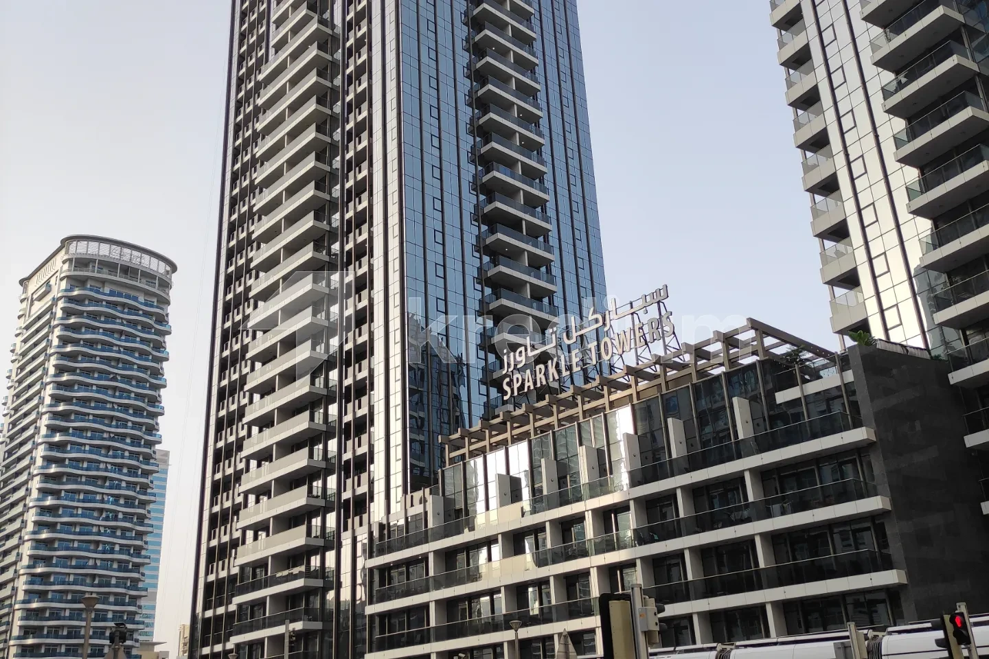 A glass high-rise building next to a smaller building with Sparkle towers sign on top