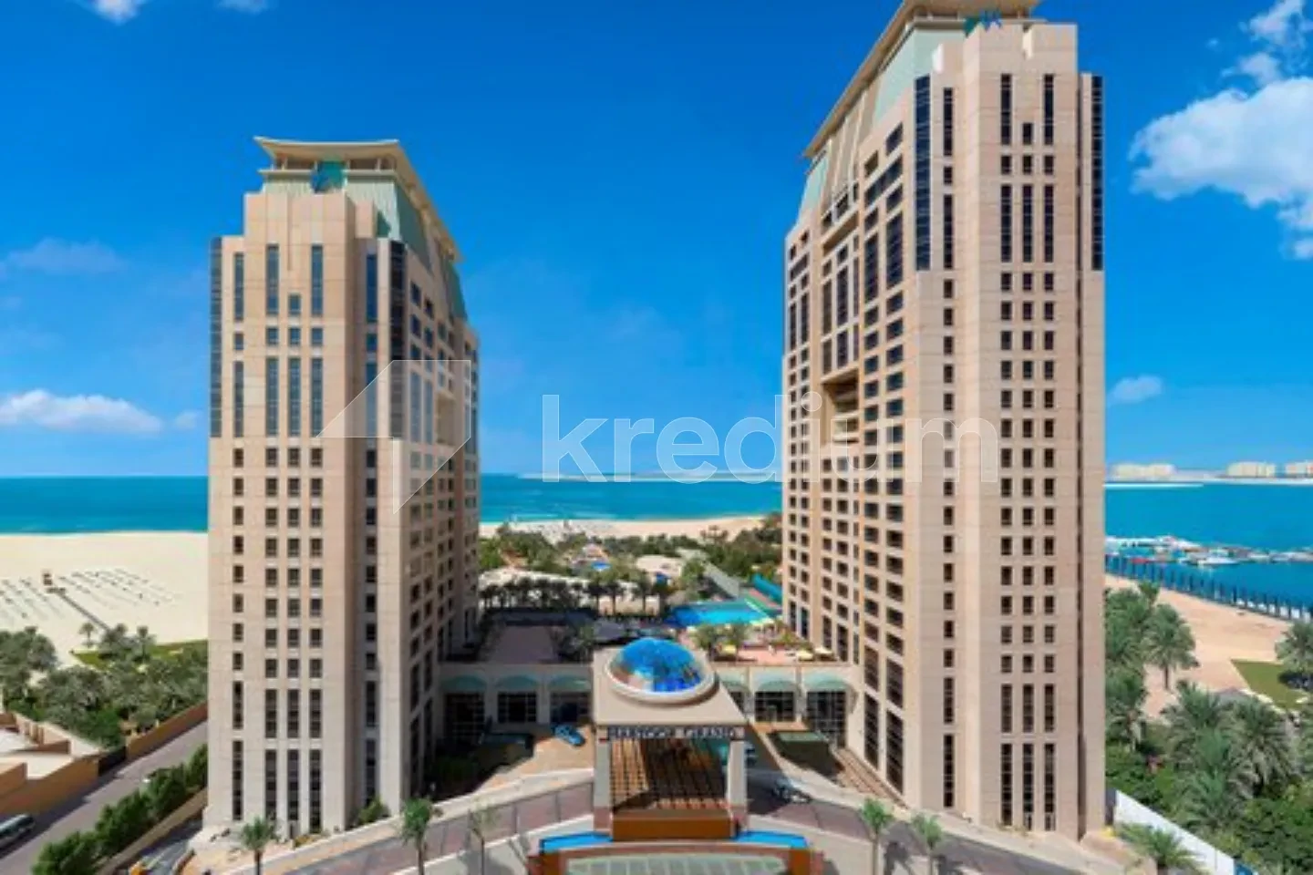 Two sleek skyscrapers with a view of the sea in the background