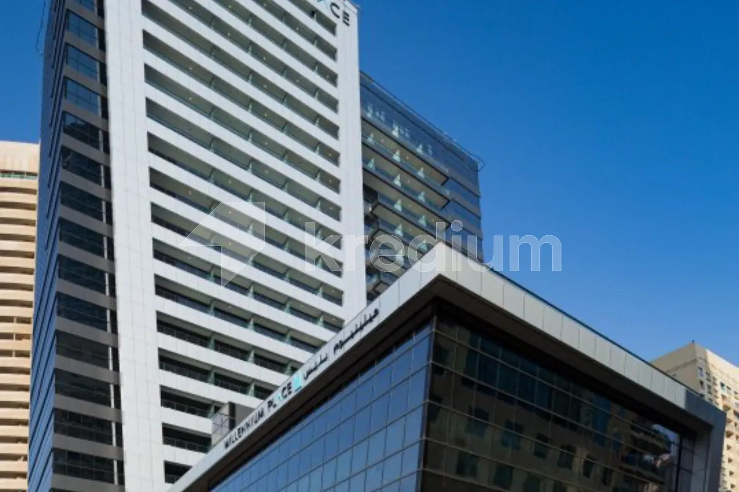 Sleek tower with a mid-rise glass building in front of it