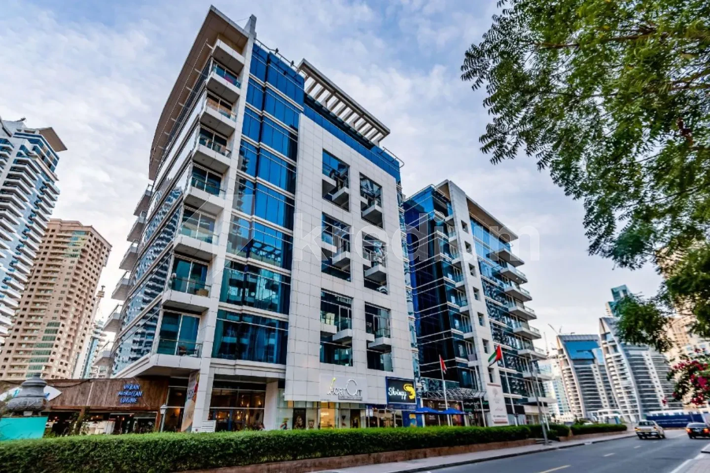 A sleek mid-rise building next to a busy street