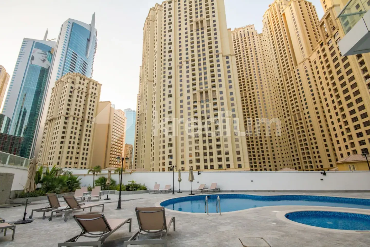 A group of tall residential buildings overlooking a swimming pool