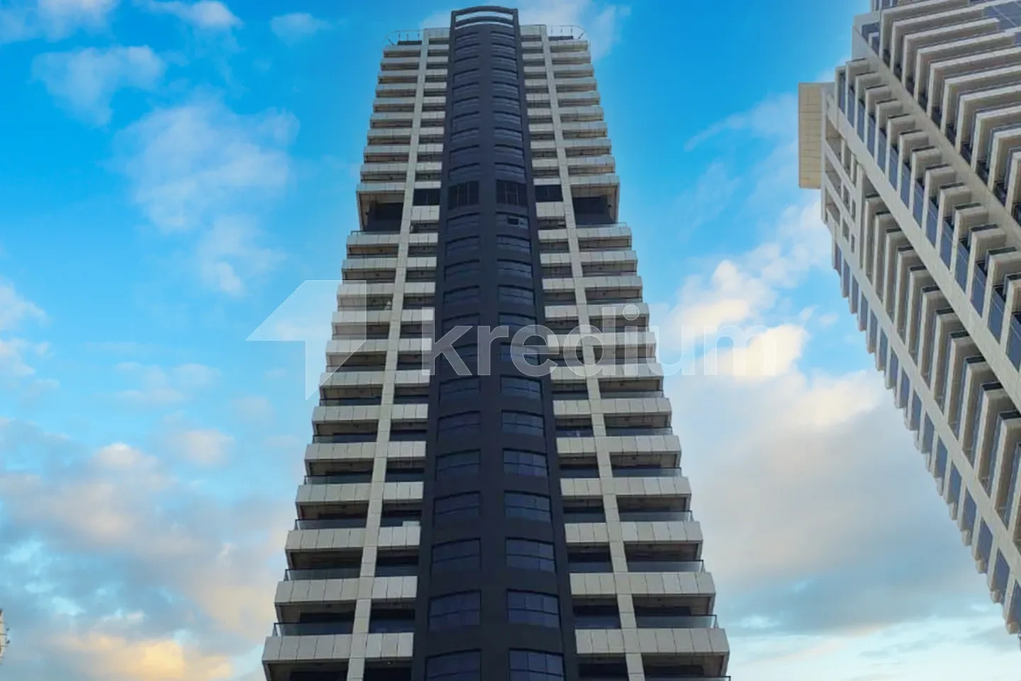 Tall residential tower with blue skies in the background