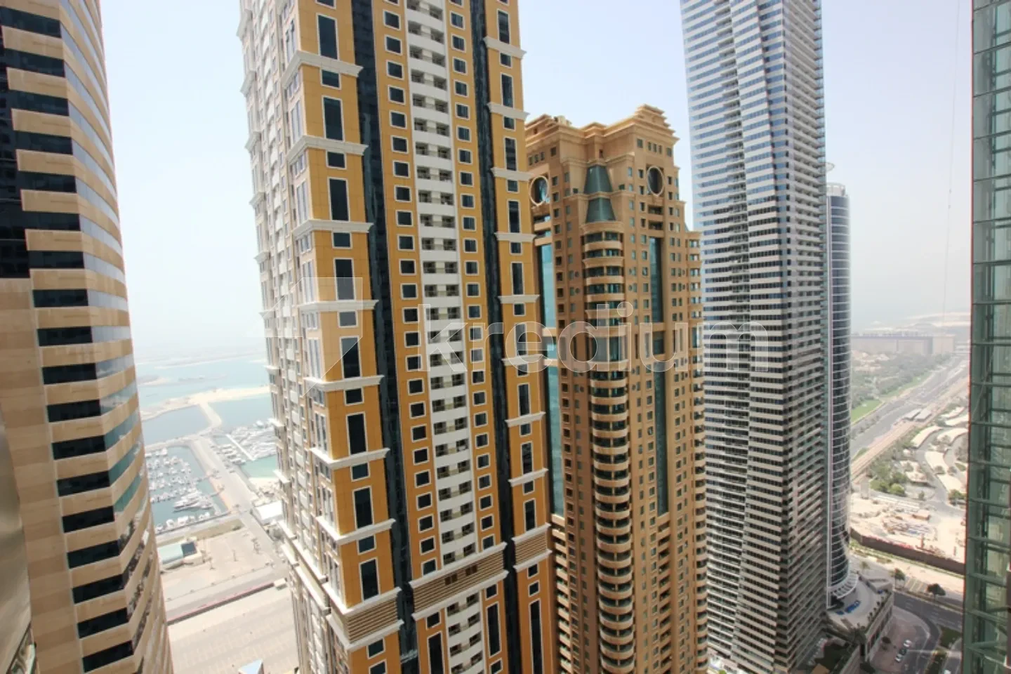 A group of elegant skyscrapers overlooking the sea and a busy road