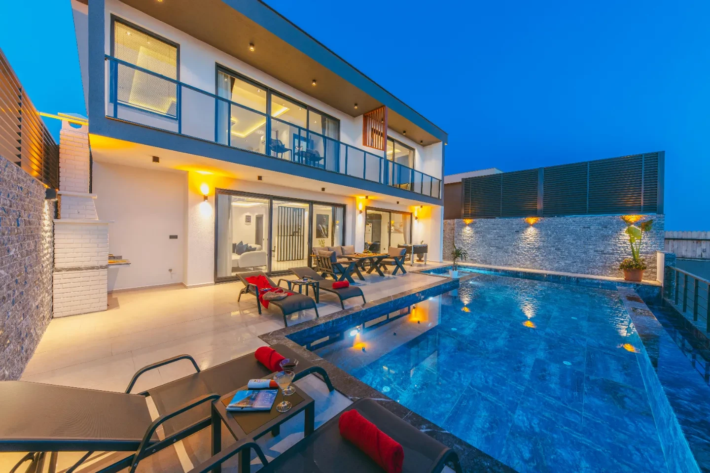 A residency with pool and sun loungers around it.