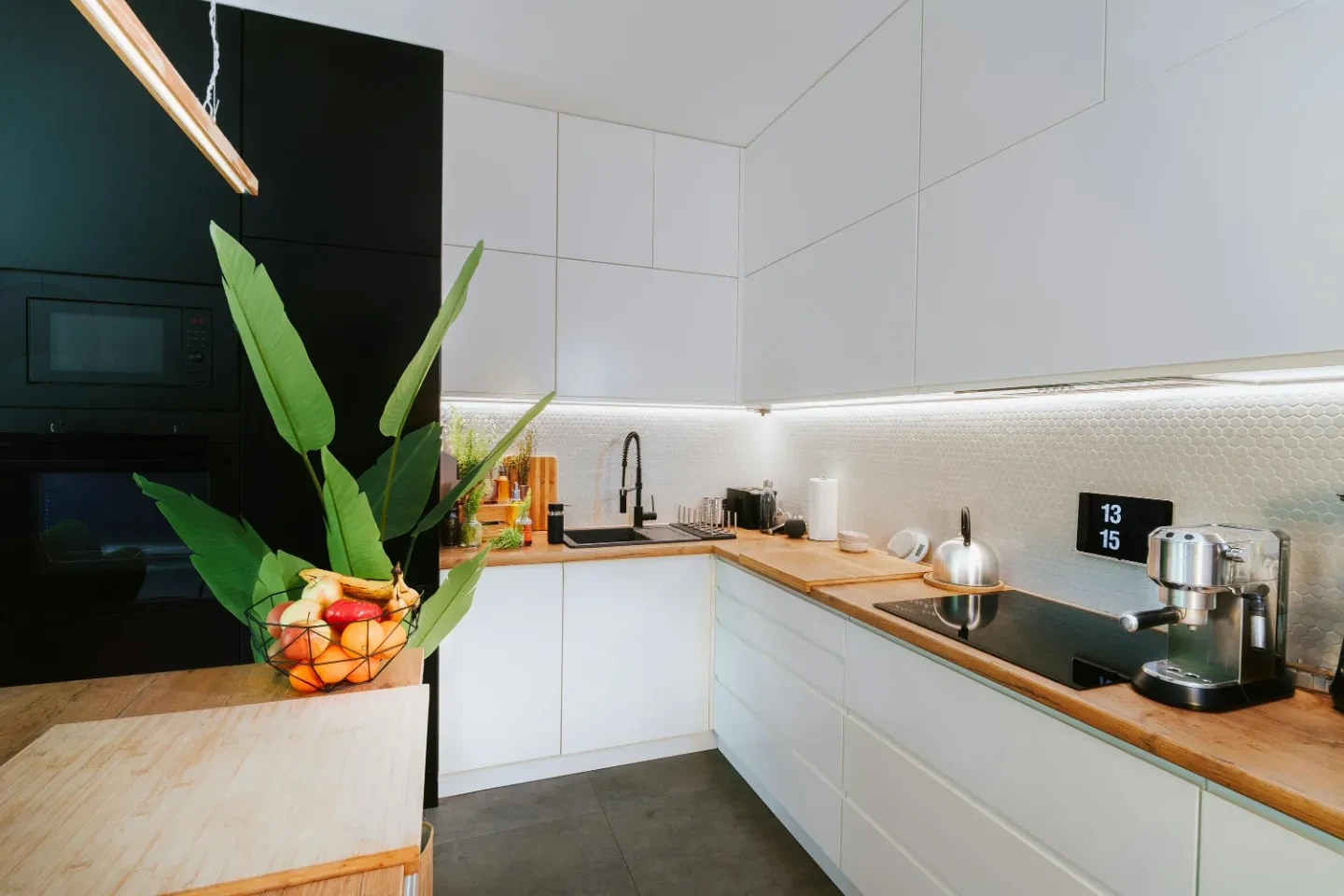 A smart home kitchen with a controlling screen above the oven.