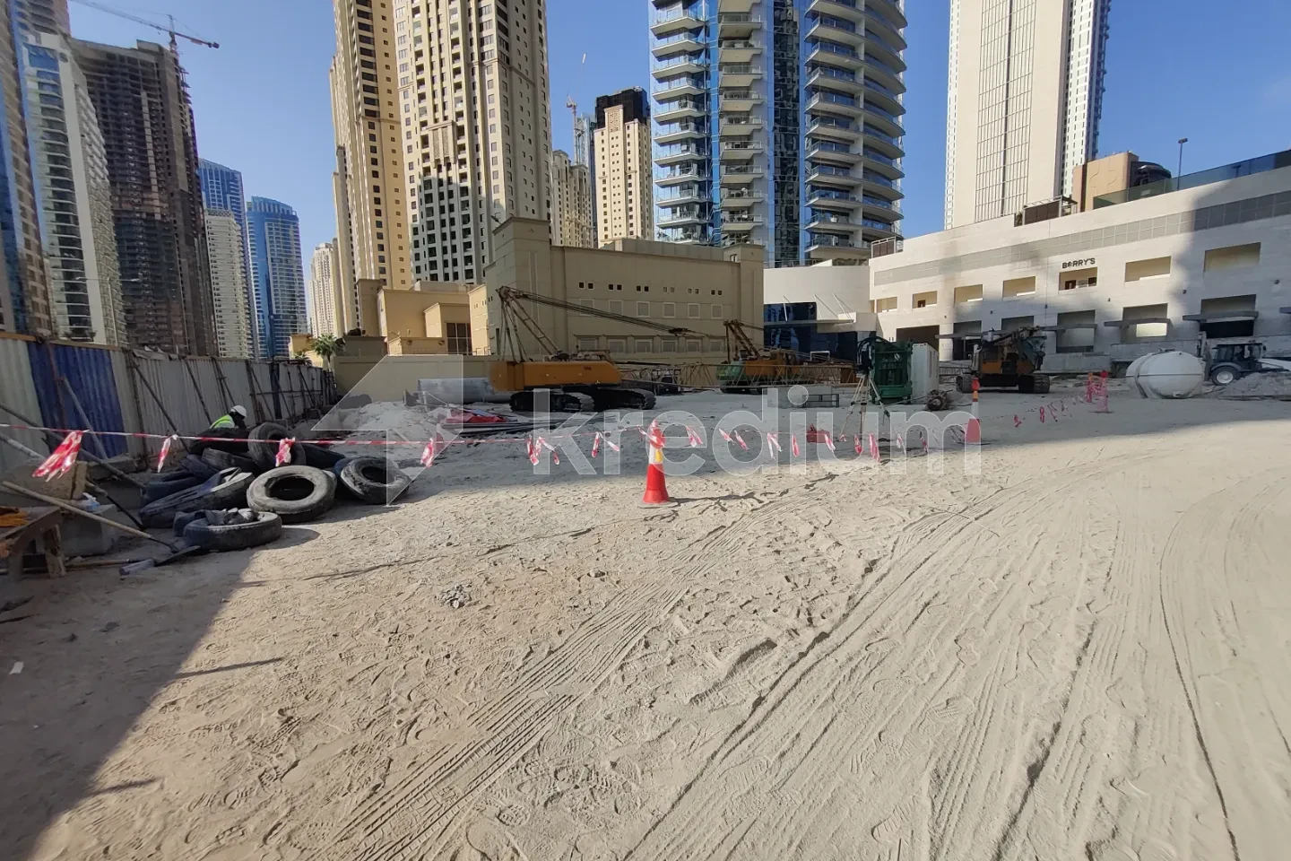 A view of a building site with modern high-rise buildings in the background