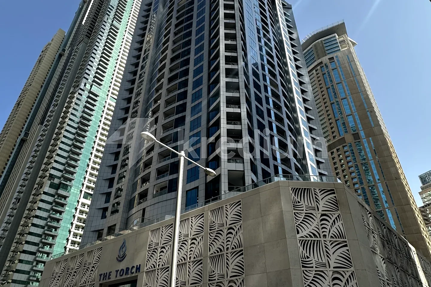 A sleek tower with the torch sign above the entrance