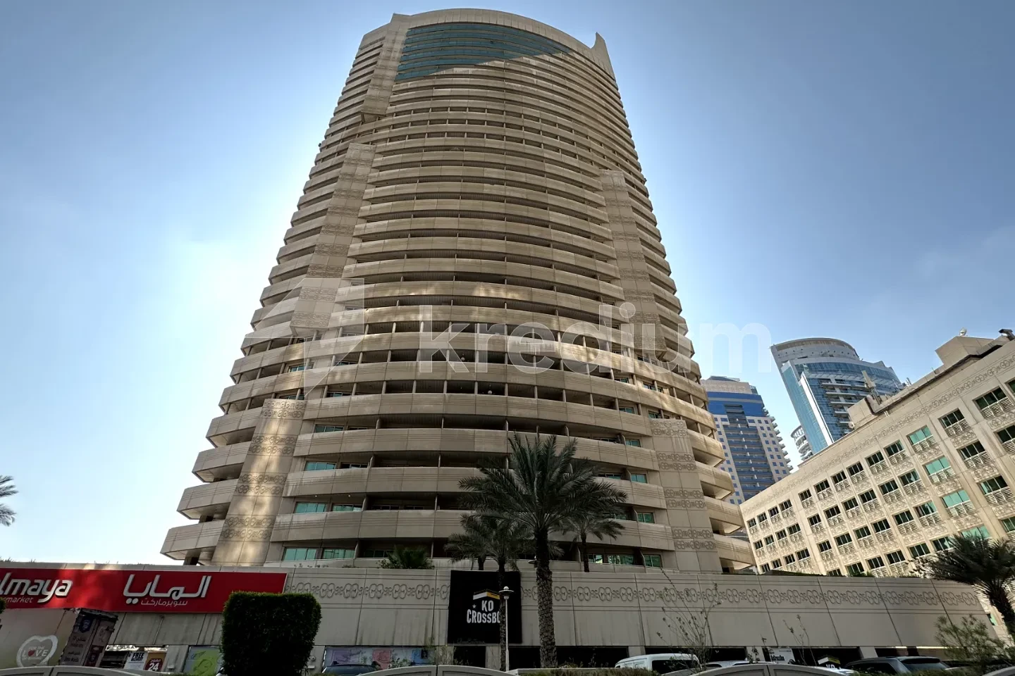 Tall modern tower with a palm tree in front of it