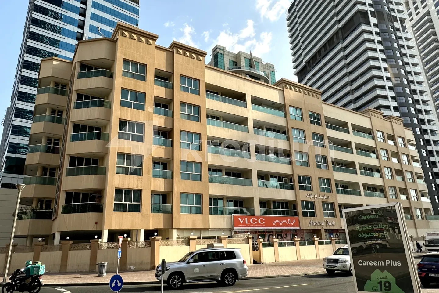 A mid-rise residential building next to a busy street