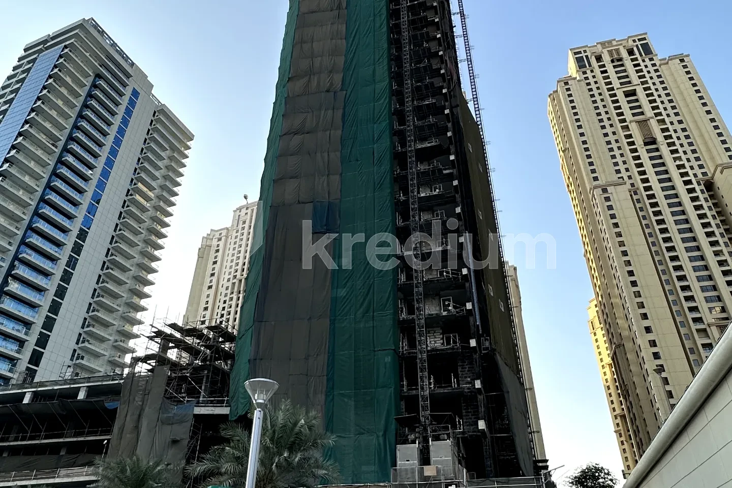 An unfinished skyscraper in a busy neighborhood